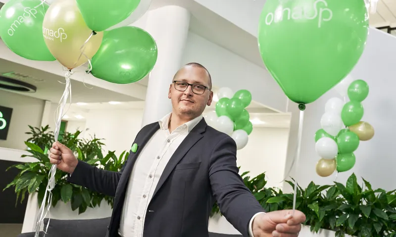 OmaSp:n asiantuntija pitää kädessään ilmapalloja.