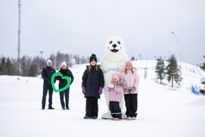 Lapsia Norppa-maskotin kanssa lumisessa maisemassa.
