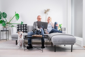 Kaksi aikusta istuu sohvalla ja katsovat kannettavaa tietokonetta