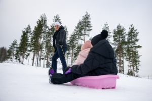 Lapsia vedetään pulkassa.