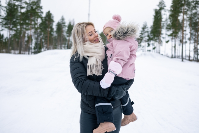 Lapsi äidin kanssa pulkkamäessä.